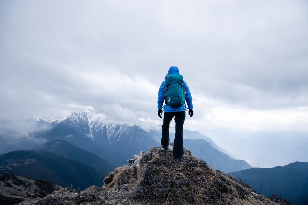 A back view of a standing on a mountain top