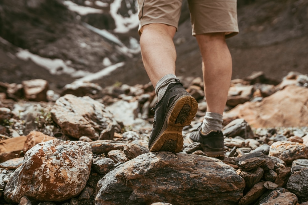 A back view of legs of a guy wearing hiking shoes