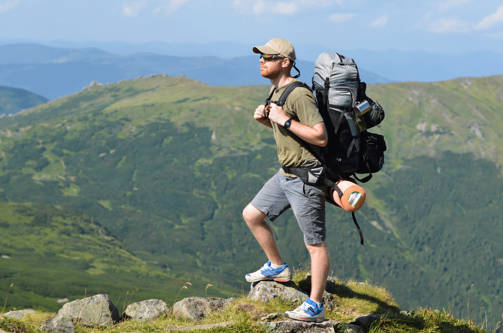 A view of a person standing on a mountain top wearing shorts