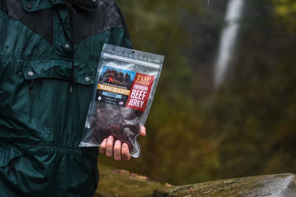 A person holding a beef jerky packet