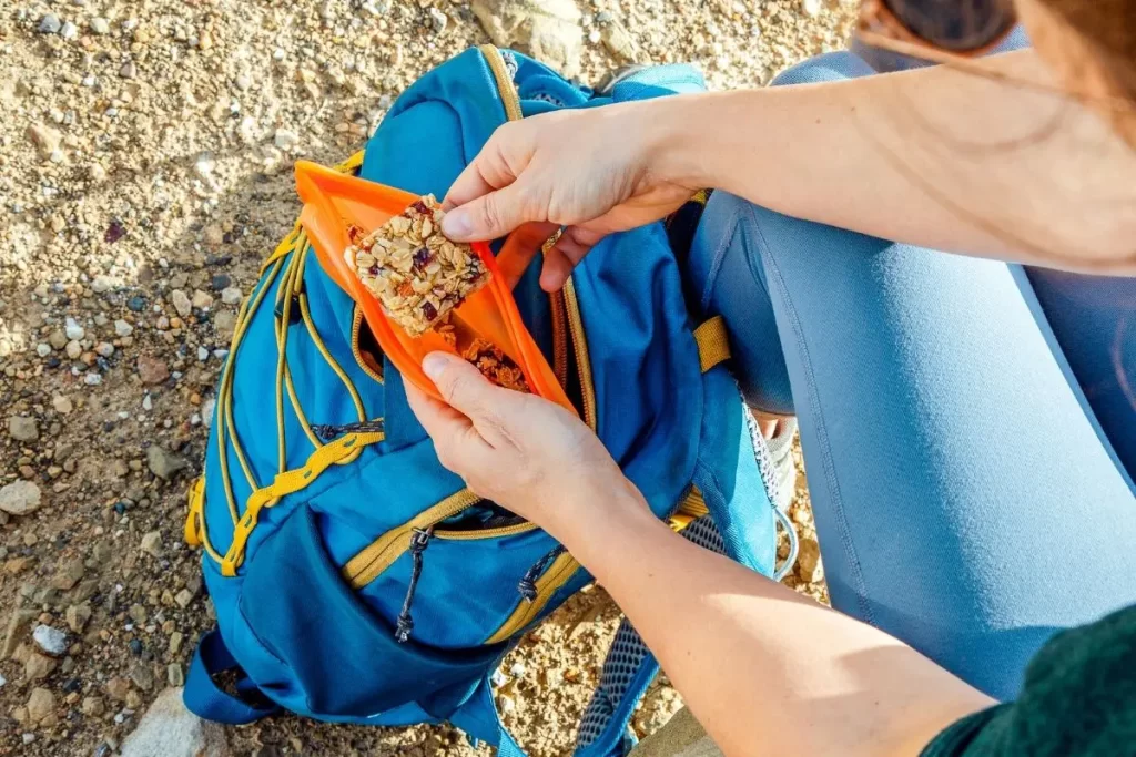 A person taking out an energy block out of a hiking backpack