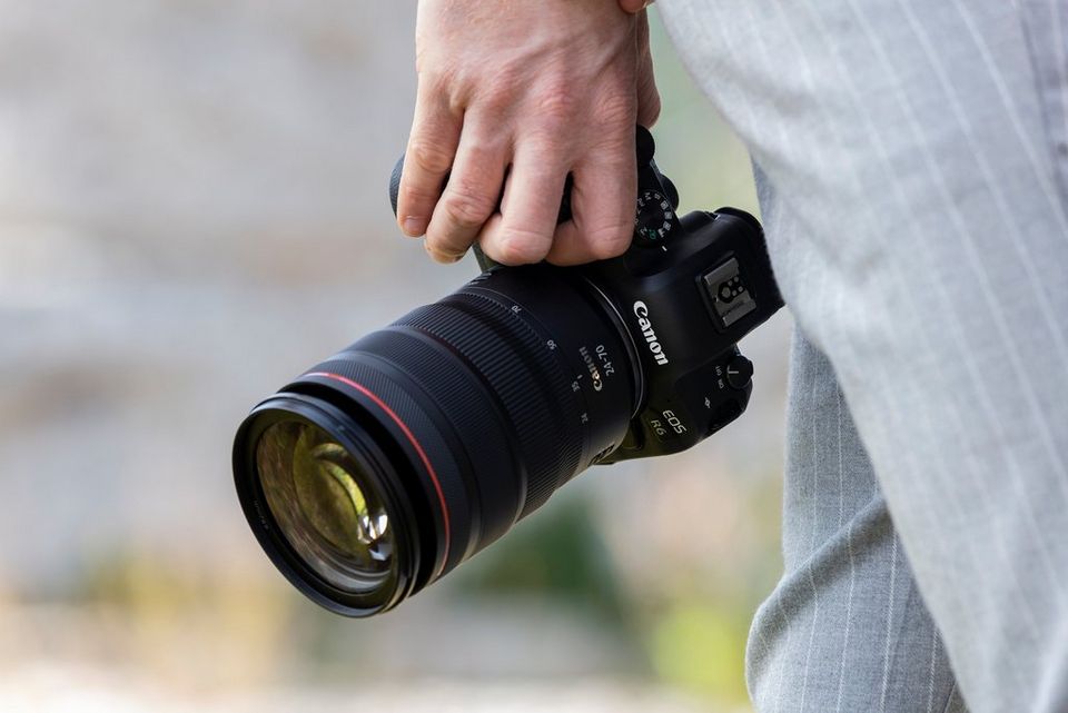 a person holding canon camera