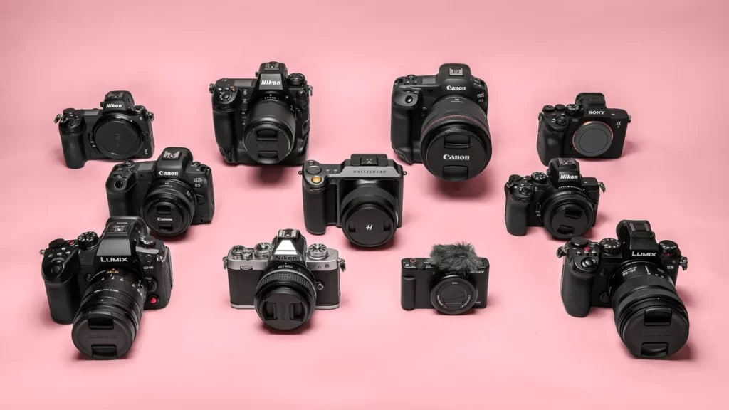 variety of cameras infront of pink background