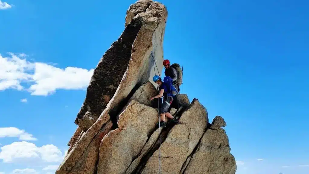 hikers climbing a rock