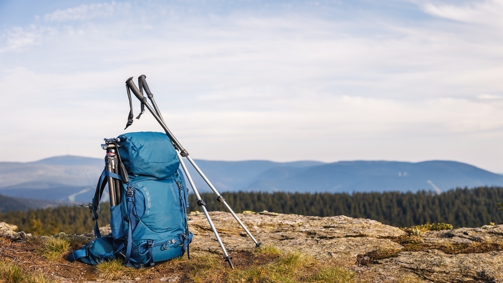 Backpack With Tripod And Hiking Pole During Trekking In Mountains