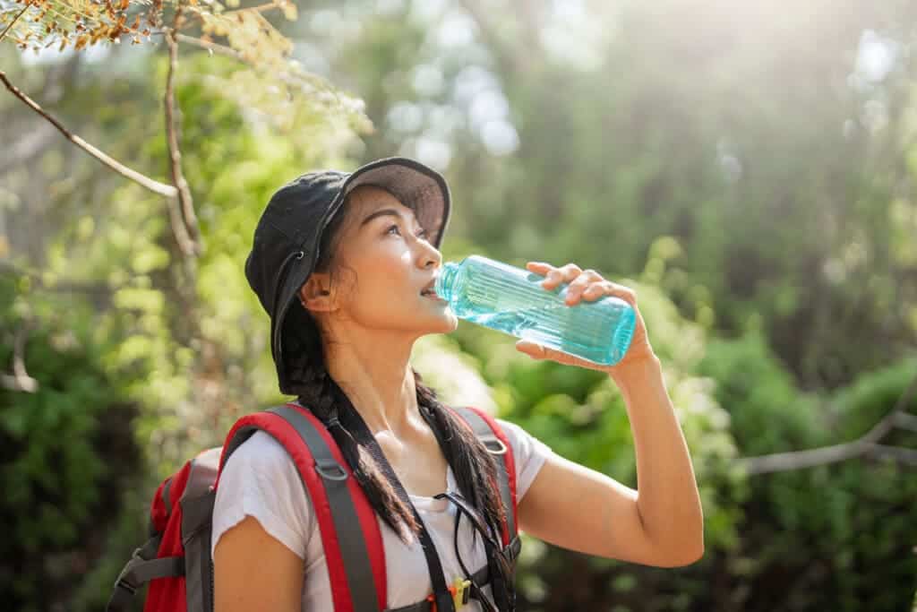 a female hiker drinking water from bottle