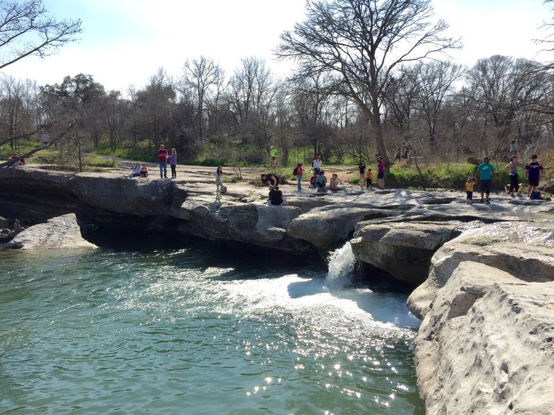 people enjoying near onion creek trail runnign water in texas