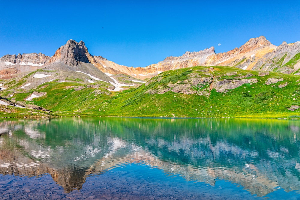 Landscape view of green meadow and Ice lake water reflection near Silverton, Colorado